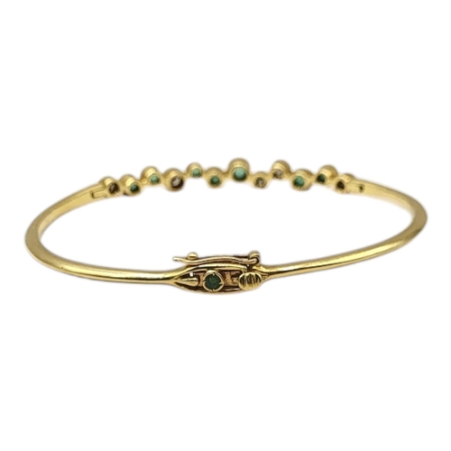 9 - A VINTAGE 18CT GOLD, EMERALD AND DIAMOND BANGLE
Having an arrangement of graduated round cut emerald... 