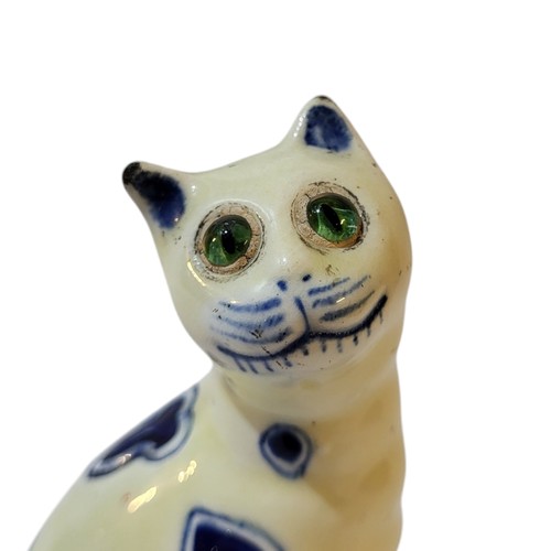 373 - A GALLE OF NANCY STYLE FAIENCE MASONIC MODEL OF A SEATED CAT, CIRCA 1900 - 1920
With blue painted he... 