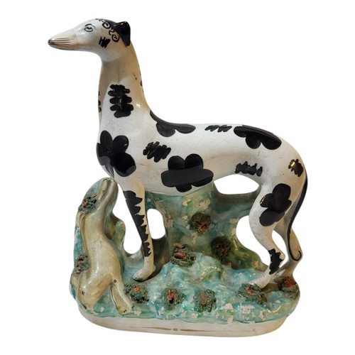 374 - A VICTORIAN STAFFORDSHIRE POTTERY MODEL OF A STANDING GREYHOUND 
With a dead rabbit, Circa 1870, dec... 