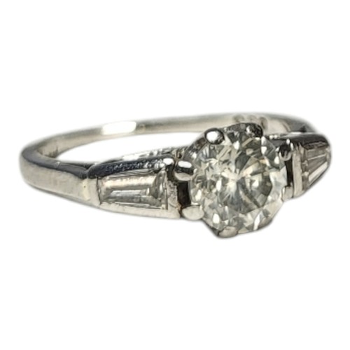 412 - A PLATINUM AND DIAMOND RING
Set with central brilliant cut diamond flanked by tapering baguette cut ... 