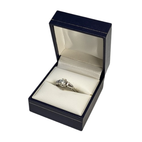 412 - A PLATINUM AND DIAMOND RING
Set with central brilliant cut diamond flanked by tapering baguette cut ... 