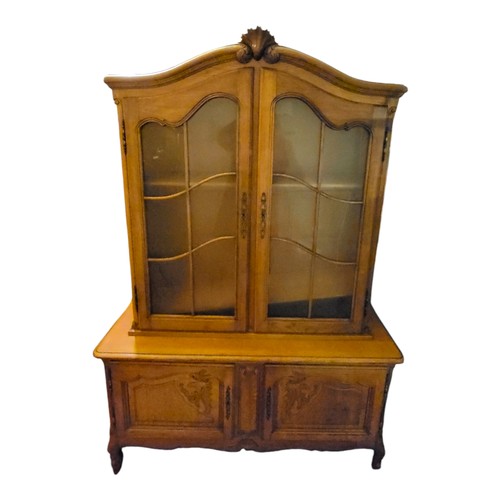 355 - A FRENCH SOLID OAK BOOKCASE/DISPLAY CABINET
The shell cartouche domed top above two glazed doors and... 