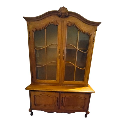 410 - A FRENCH SOLID OAK BOOKCASE/DISPLAY CABINET
The shell cartouche domed top above two glazed doors and... 