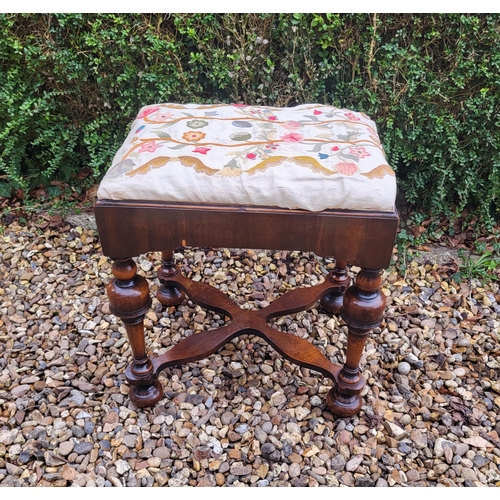 313 - AN 18TH/19TH CENTURY QUEEN ANNE STOOL
With crewel work cover, above solid apron, raised on four cup ... 