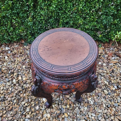 322 - A CHINESE CARVED HARDWOOD PLANT STAND
The circular top above pierced apron figured with bats, on fou... 