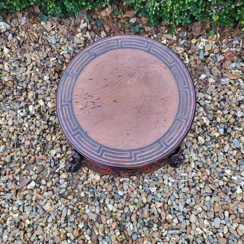 322 - A CHINESE CARVED HARDWOOD PLANT STAND
The circular top above pierced apron figured with bats, on fou... 