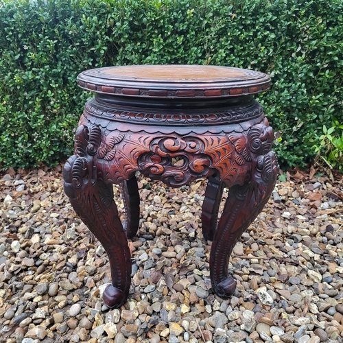 322 - A CHINESE CARVED HARDWOOD PLANT STAND
The circular top above pierced apron figured with bats, on fou... 