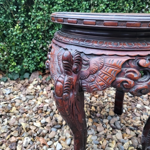 322 - A CHINESE CARVED HARDWOOD PLANT STAND
The circular top above pierced apron figured with bats, on fou... 