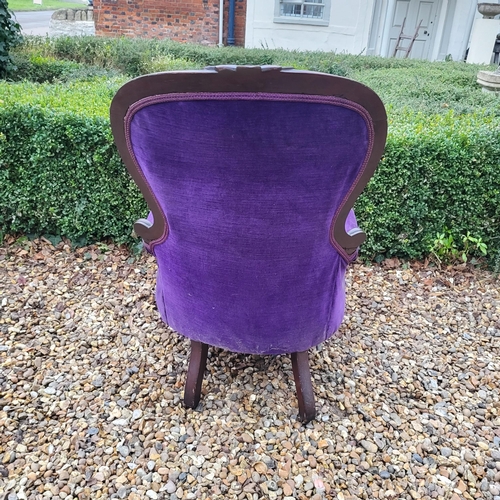 324 - A VICTORIAN MAHOGANY FRAMED SPOON BACK ARMCHAIR
In deep purple button back upholstery, scroll arm, o... 