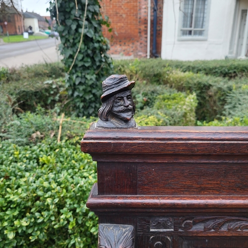 329 - A VICTORIAN OAK TWO SEAT SETTLE
With facial mask finials above panels carved with tavern scenes, arm... 