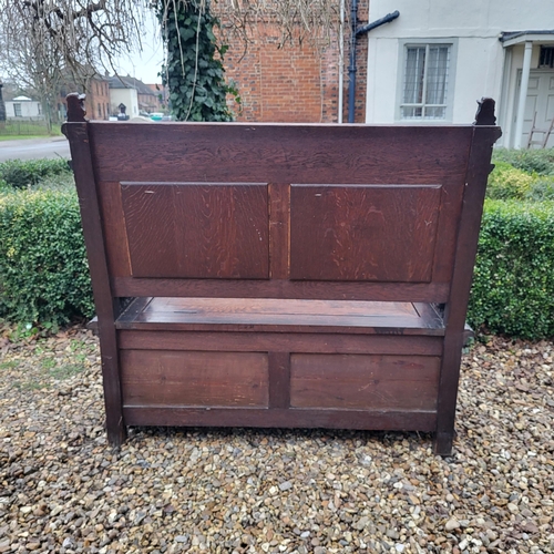 329 - A VICTORIAN OAK TWO SEAT SETTLE
With facial mask finials above panels carved with tavern scenes, arm... 