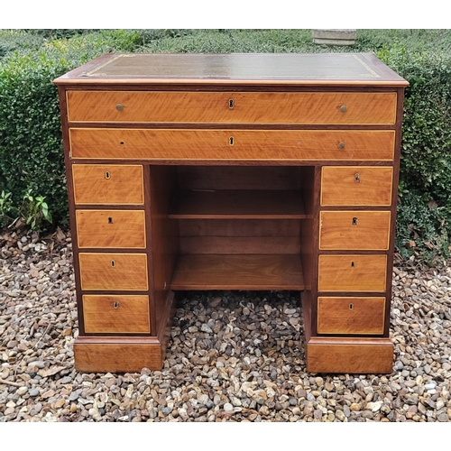 336 - A 19TH CENTURY MAHOGANY AND SATINWOOD KNEEHOLE DESK
With tooled leather writing surface above an arr... 