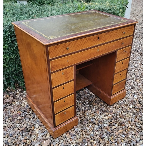 336 - A 19TH CENTURY MAHOGANY AND SATINWOOD KNEEHOLE DESK
With tooled leather writing surface above an arr... 