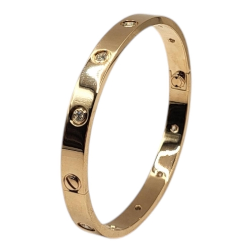 80 - CARTIER, AN 18CT GOLD AND DIAMOND LOVE BANGLE
Set with ten round cut diamonds and screw head clasp, ... 