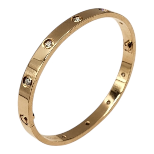 80 - CARTIER, AN 18CT GOLD AND DIAMOND LOVE BANGLE
Set with ten round cut diamonds and screw head clasp, ... 