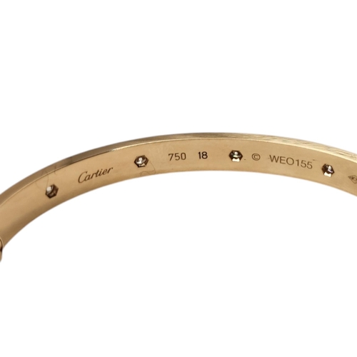 80 - CARTIER, AN 18CT GOLD AND DIAMOND LOVE BANGLE
Set with ten round cut diamonds and screw head clasp, ... 