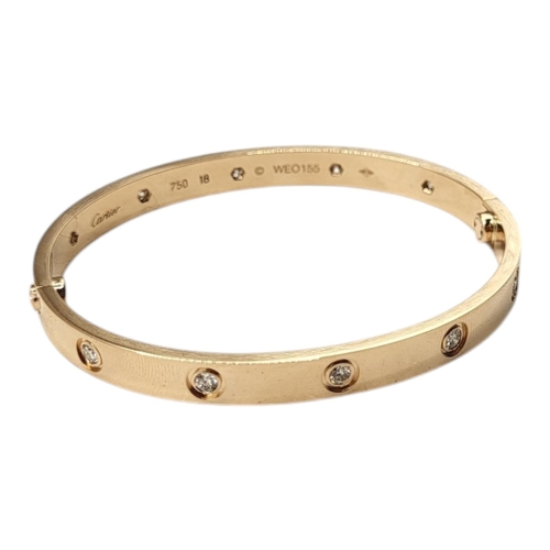 80 - CARTIER, AN 18CT GOLD AND DIAMOND LOVE BANGLE
Set with ten round cut diamonds and screw head clasp, ... 