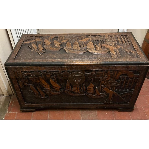 376 - A CHINESE CARVED CAMPHOR WOOD COFFER.
(w 105cm x d 53cm x h 56cm)