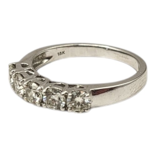 83 - AN 18CT WHITE GOLD AND DIAMOND FIVE STONE RING
The row of round cut diamonds set in a plain design, ... 