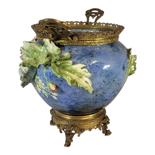 103 - A 19TH CENTURY FAIENCE POTTERY AND GILT BRASS JARDINIERE
Twin handles with pierced gallery rim and m... 