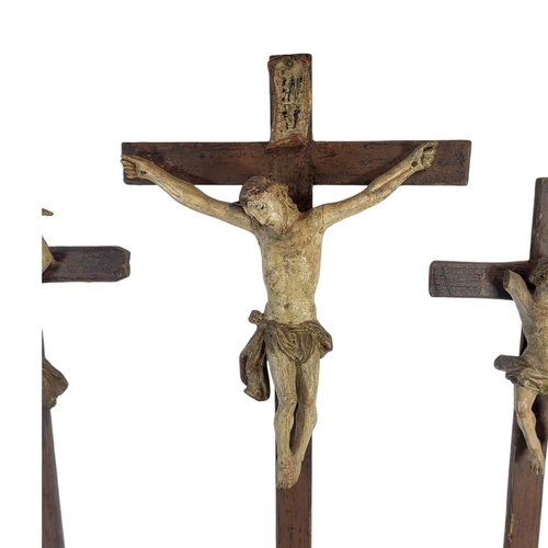 188 - A 19TH CENTURY CARVED WOOD AND POLYCHROME GROUP CRUCIFIXION SCENE
Central figure of Christ flanked b... 