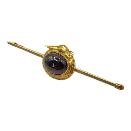 27 - A 19TH CENTURY YELLOW METAL AND GARNET ‘BUCKLE’ BROOCH
Cabochon cut stone within a belt design, in a... 