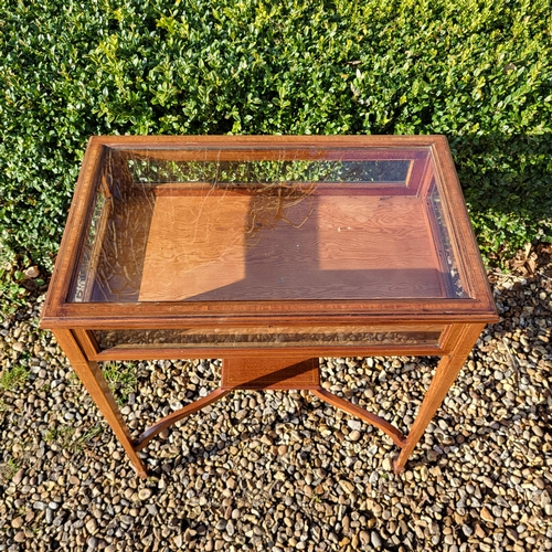 351 - AN EDWARDIAN MAHOGANY AND LINE INLAID BIJOUTERIE TABLE
The glazed top raised on square tapering legs... 