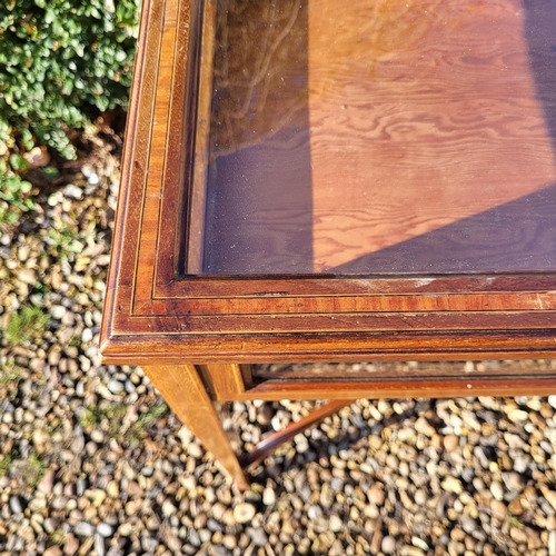 351 - AN EDWARDIAN MAHOGANY AND LINE INLAID BIJOUTERIE TABLE
The glazed top raised on square tapering legs... 