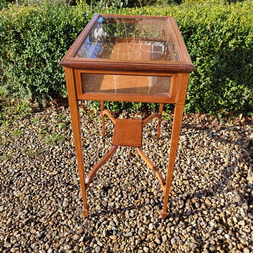 351 - AN EDWARDIAN MAHOGANY AND LINE INLAID BIJOUTERIE TABLE
The glazed top raised on square tapering legs... 