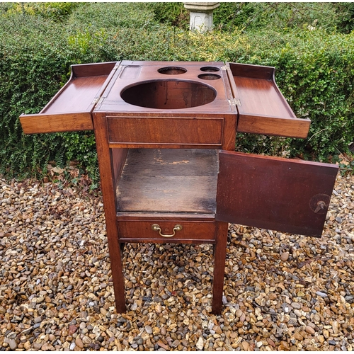 357 - A GEORGIAN MAHOGANY GENTLEMAN'S WASHSTAND
The fold over top enclosing a fitted interior above cupboa... 