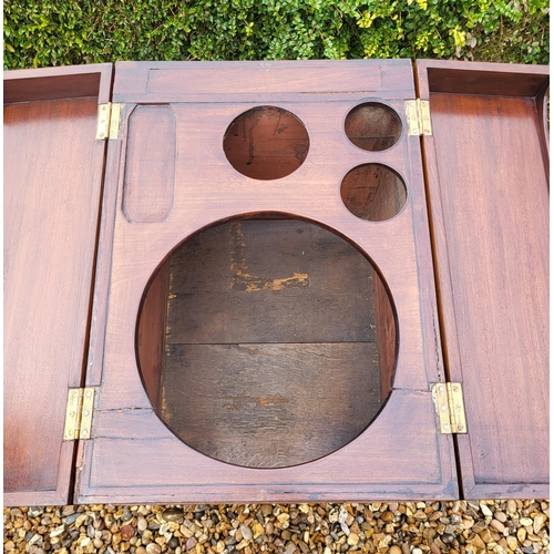 357 - A GEORGIAN MAHOGANY GENTLEMAN'S WASHSTAND
The fold over top enclosing a fitted interior above cupboa... 