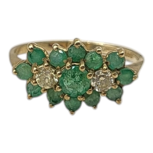 52 - A VINTAGE 9CT GOLD, EMERALD AND DIAMOND CLUSTER RING 
Having an arrangement of round cut emeralds in... 