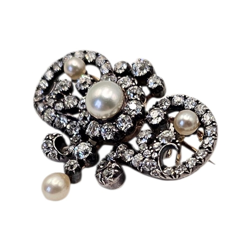 12 - A LATE VICTORIAN/EDWARDIAN YELLOW METAL NATURAL PEARL AND DIAMOND SCROLL BROOCH
The openwork foliate... 