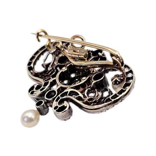 12 - A LATE VICTORIAN/EDWARDIAN YELLOW METAL NATURAL PEARL AND DIAMOND SCROLL BROOCH
The openwork foliate... 