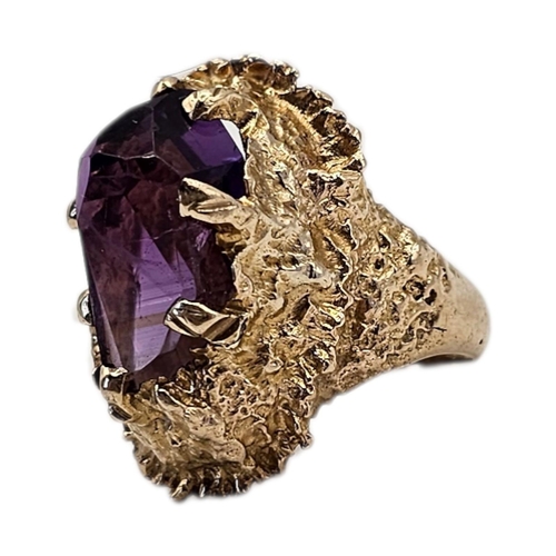 21A - A VINTAGE 9CT GOLD AND AMETHYST RING
Faceted central stone in a textured organic mount.
(size Q, app... 