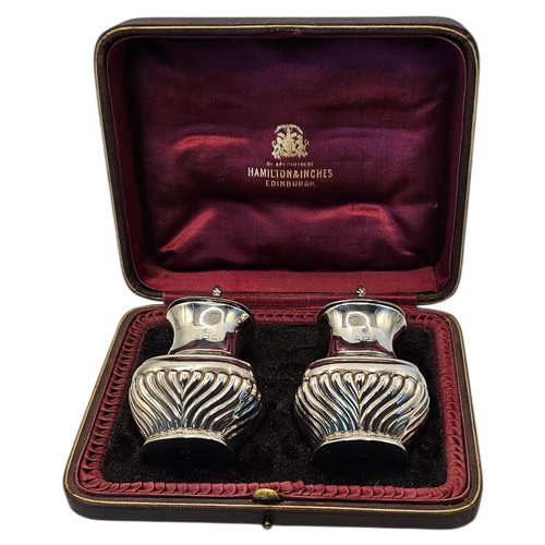 27 - A PAIR OF EARLY 20TH CENTURY SILVER PEPPERETTES
Classical form with fluted decoration, in a fitted v... 
