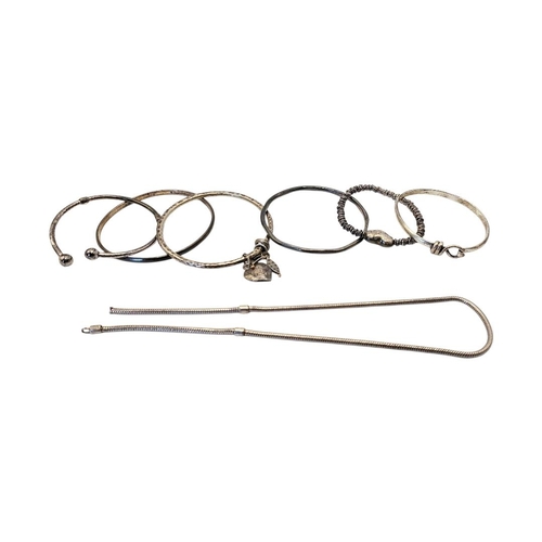 63 - A COLLECTION OF VINTAGE SILVER AND WHITE METAL BANGLES
To include a bangle with heart form fob.
(app... 