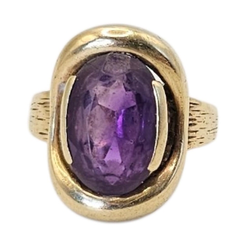78 - A VINTAGE 9CT GOLD AND AMETHYST GENTS SIGNET RING
Oval cut stone with engraved bark decoration to sh... 