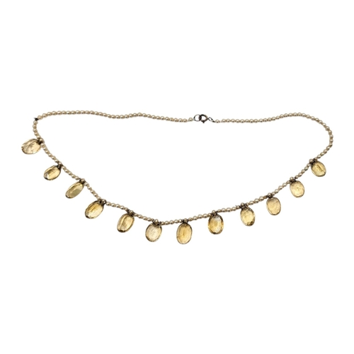 139 - AN EARLY 20TH CENTURY CITRINE AND SEED PEARL NECKLACE
Row of the Elbe oval cut stones on a five seed... 