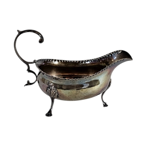 4 - A GEORGIAN SILVER SAUCE BOAT
Serrated edge with single handle, on tripod legs, hallmarked 1782.
(app... 