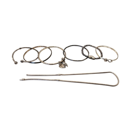 63 - A COLLECTION OF VINTAGE SILVER AND WHITE METAL BANGLES
To include a bangle with heart form fob.
(app... 