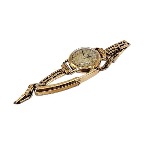 65 - EVERITE, A VINTAGE 9CT GOLD LADIES’ WRISTWATCH
Having Arabic number markings, on a rolled gold brace... 