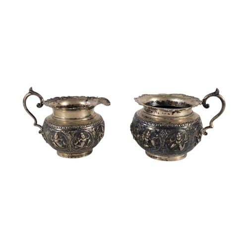 71 - A PAIR OF EARLY ANGLO-INDIAN SILVER REPOUSSÉ SUGAR AND CREAM JUGS
A late 19th Century cream jug and ... 