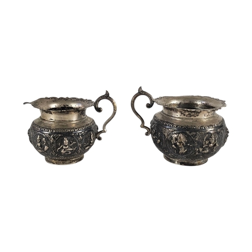 71 - A PAIR OF EARLY ANGLO-INDIAN SILVER REPOUSSÉ SUGAR AND CREAM JUGS
A late 19th Century cream jug and ... 