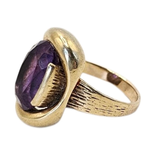 78 - A VINTAGE 9CT GOLD AND AMETHYST GENTS SIGNET RING
Oval cut stone with engraved bark decoration to sh... 