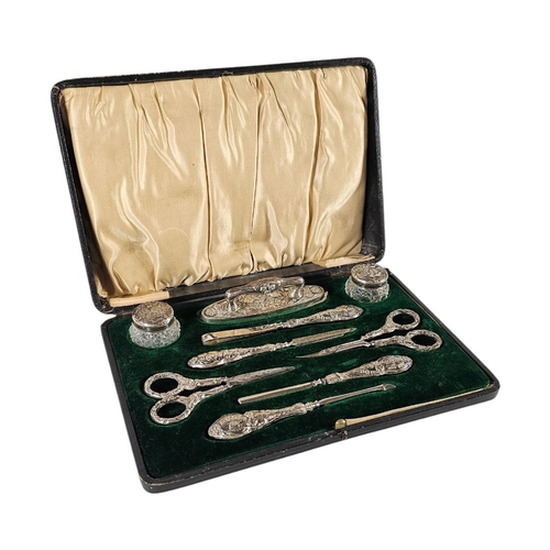 94 - AN EARLY 20TH CENTURY SILVER ‘REYNOLDS ANGELS’ MANICURE SET
To include two glass rouge pots ,nail sc... 