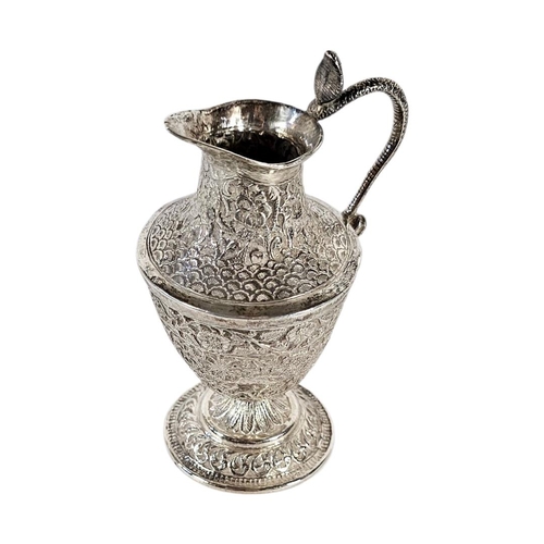 20 - AN EARLY 20TH CENTURY INDIAN SILVER CREAM JUG
Having chased decoration of animals within foliage.
(a... 