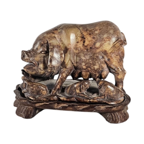 22 - AN EARLY 20TH CENTURY CHINESE CARVED SOAPSTONE GROUP OF A SOW AND PIGLETS
The mottled honey coloured... 