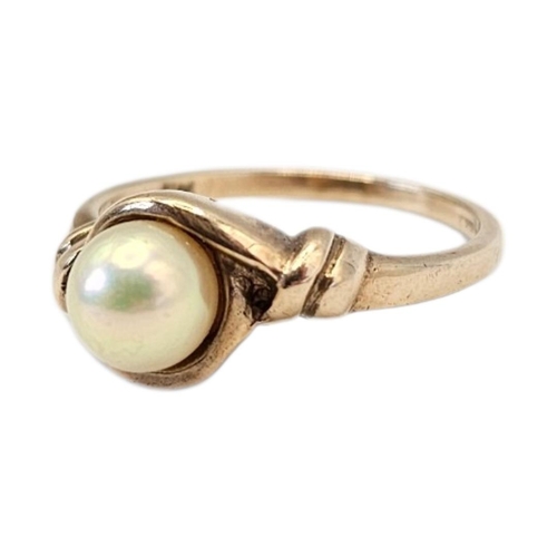 6 - A VINTAGE 9CT GOLD AND PEARL SOLITAIRE RING 
The single pearl in a rope twist design.
(size P, appro... 