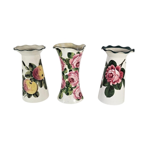 60 - WEMYSS WARE, A COLLECTION OF THREE EARLY 20TH CENTURY POTTERY VASES
Having flared rims and painted d... 